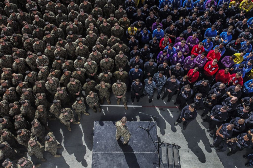 U.S. Marine Maj. Gen. Carl E. Mundy III, middle, speaks to Marines and Sailors aboard the USS Essex (LHD 2) during Amphibious Squadron/Marine Expeditionary Unit Integration Training (PMINT) at sea Feb. 26, 2015. Mundy is the commander, Task Force 51. Mundy spoke to the Marines and sailors of the 15th Marine Expeditionary Unit and Essex Amphibious Ready Group about the importance of working together as a blue/green team during their upcoming deployment. (U.S. Marine Corps photo by Cpl. Steve H. Lopez/Released)